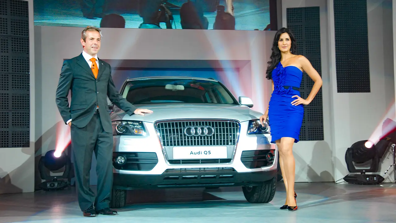 Audi Q5 launch photo moment with car reveal and celebrity guest, showcasing brand storytelling and automotive event staging