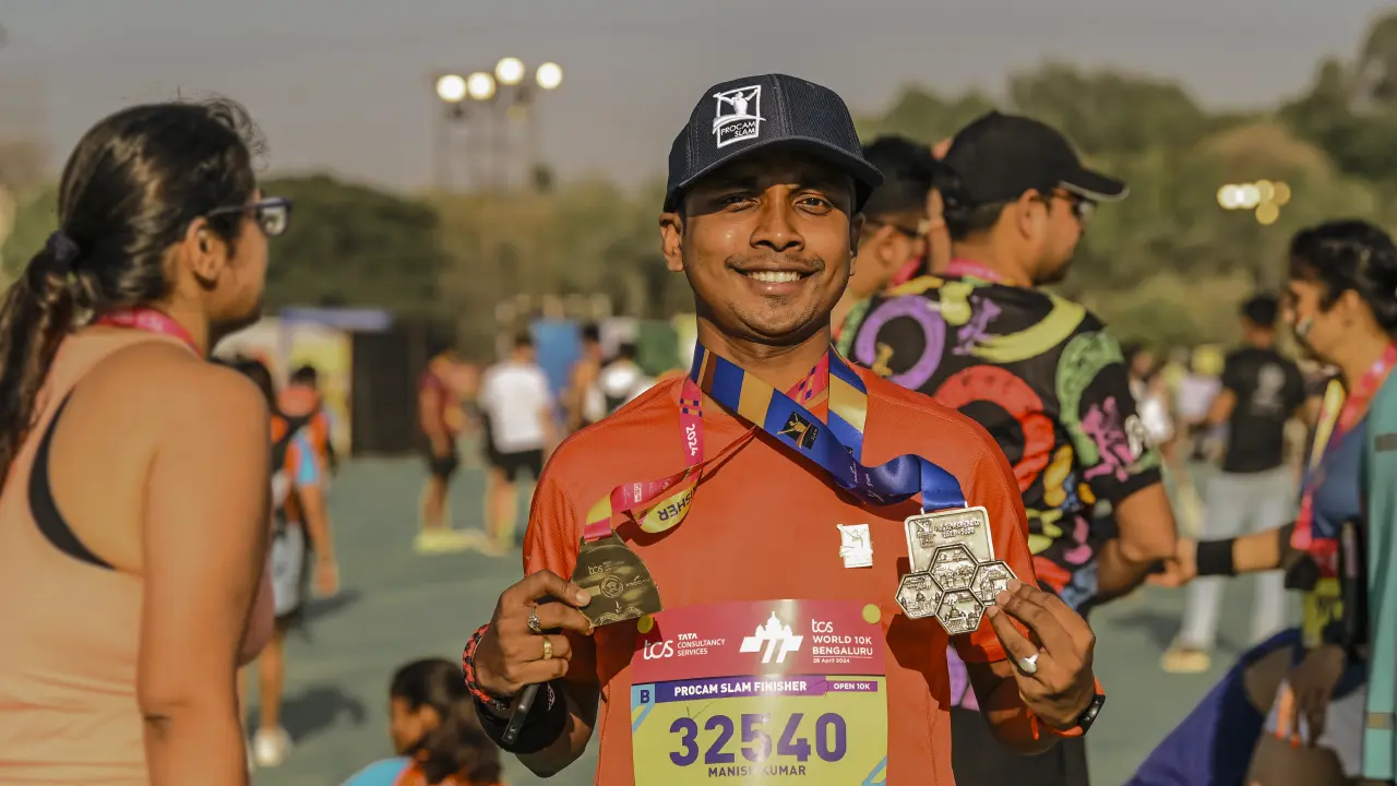 Procam Slam finisher at TCSW10K Bengaluru holding medal on stage